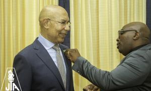 JTA President Leighton Johnson is given his Excellency's blessings to pin him with the JTA 60th anniversary pin during a recent courtesy call on King's House.