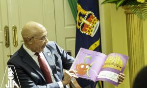 The Governor General His Excellency, Sir Patrick Allen reads to students of Mona Heights Primary and Half Way Tree Primary during a visit by the students to King's House during the JTA's Read Across Jamaica Day.