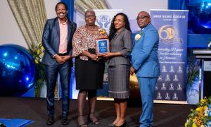 Receiving the Golden Torch Award from State Minister for Education and Youth, Marsha Smith for her 45 years of service to education. Participating also are Opposition Spokesman on Education, Damion Crawford (left) and JTA President, Leighton Johnson (right).