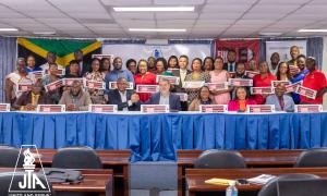 Some members of the JTA Central Executive for 2025 make a statement with their Go Public signs as they attended the two day fora on Friday and Saturday, March 21 and 22, 2025